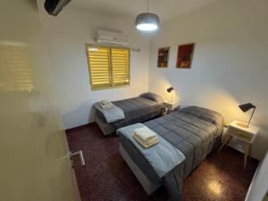 zwei Betten in einem kleinen Zimmer mit Fenster in der Unterkunft Departamento Centro - San Miguel De Tucumán in San Miguel de Tucumán