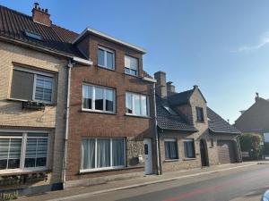 a brick house on the side of a street at Maison Lymoen, gezellige gloednieuwe woning aan zee in De Panne