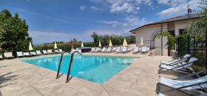 a swimming pool with lounge chairs and a building at Gardaworld Oasis in Castelnuovo del Garda