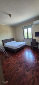 a large bedroom with a bed and a wooden floor at Gardaworld Oasis in Cavalcaselle