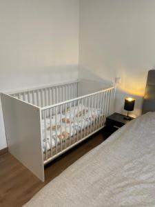 a crib in a bedroom with a bed at Wohlfühlen bei DG in Kassel