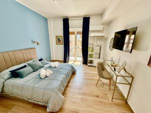 a bedroom with a bed and a desk and a television at La Zisa Luxury Apartment in Palermo