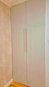 a white cabinet with two doors in a room at Comfy and modern private room in Birmingham 