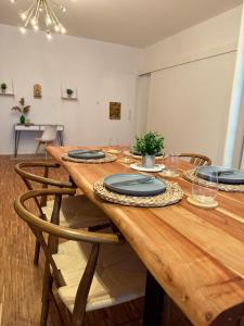 a long wooden table with chairs and plates on it at Boho Loft Apartment am Ziegeltor in Amberg