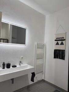 a white bathroom with a sink and a mirror at Boho Loft Apartment am Ziegeltor in Amberg