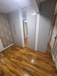 an empty room with a mirror and wood floors at Comfy and modern private room in Birmingham 