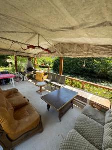 a patio with couches and a table in a tent at Studio St Florentin 2 in Saint-Florentin +14 photos