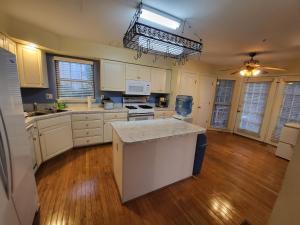 a large kitchen with white cabinets and a hard wood floor at Cara Drive Room in Springdale