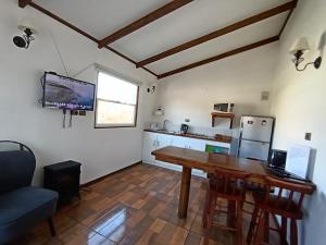 a kitchen with a wooden table in a room at Cabañas Los Tamarindos in Algarrobo