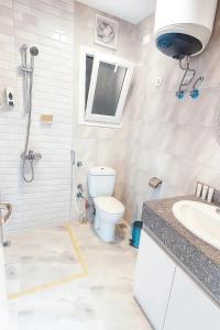 a white bathroom with a toilet and a sink at Selena Bay Luxury Sea View 1BR Apartment, Private Beach and Pool in Hurghada