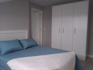 a bedroom with a large bed with white cabinets at Amaral Recuncho in Boiro
