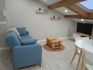sala de estar con silla azul y TV en Amaral Recuncho, en Boiro