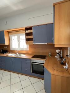 a kitchen with blue cabinets and a stove and a sink at JET, luxury appartment 20m from the beach in Kini