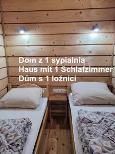 two beds in a room with wooden walls at Ośrodek Wypoczynkowy Feniks in Pogorzelica