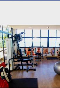 ジョアンペソアにあるHotel Tambau Flat particular908のジム付きの客室で、人々が背景を見ることができます。