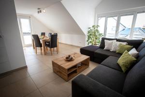 una sala de estar con un sofá y una mesa en Ferienwohnungen Kaiser, en Höchenschwand