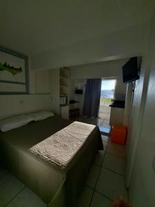 a bedroom with a bed and a view of a kitchen at Pousada Vila do Navegante in Bombinhas +110 photos