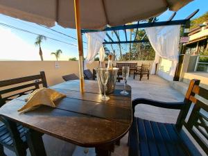 a wooden table with an umbrella on a patio at Pousada Vila do Navegante in Bombinhas