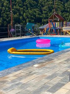 two yellow and pink frisbees in a swimming pool at Apartmani Stankovic in Crni Vrh