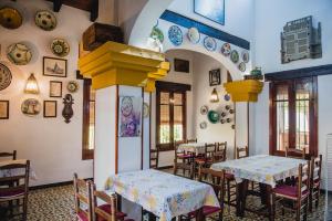 Villanueva del AriscalにあるLa casa de Marifé, a 15" de Sevilla y a 30" del aeropuertoの壁にテーブルと皿が置かれたレストラン
