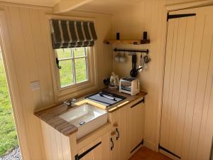 a small kitchen with a sink and a window at Cosy Shepherd Hut in Kempsford