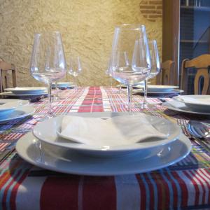 stół z talerzami i kieliszkami do wina w obiekcie SueñoRural w mieście San Miguel de Valero