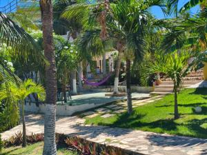 a resort with palm trees in the yard at Casa no Residencia Familia in Canoa Quebrada