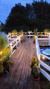 a wooden deck with lights and potted plants on it at Agroturystyka Wypoczynkowa II in Zieleniewo