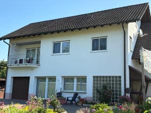 a white house with a balcony at Naturblick am Dorfausgang in Rheinau