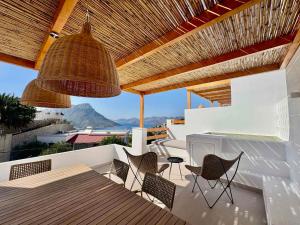 a patio with chairs and a table with a view at The Kalymnos Cliff Apartments in Kalymnos