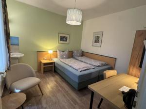 a small bedroom with a bed and a table at Hotel Am Ehrenhof in Düsseldorf