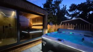 a hot tub in a yard next to a window at LUNA Luxury Apartments - Adults Only - sauna, jacuzzi in Szklarska Poręba