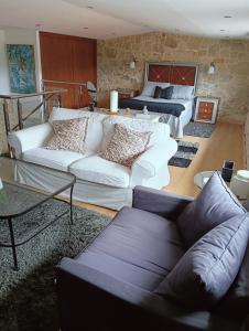 un soggiorno con un divano e un letto di Casa Consuelo a Sabardes