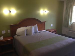 a bedroom with a large bed with white pillows at Red Carpet Inn - New Brunswick in New Brunswick