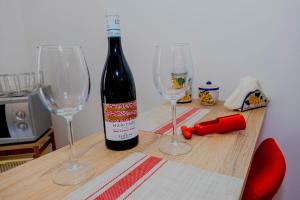 a bottle of wine sitting on a table with two wine glasses at Al Manzil in Locogrande