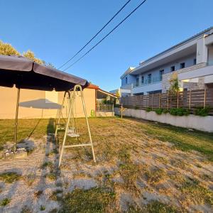 a swing set in a yard next to a building at Casa Chinook Sea View Homes-Porto Koufo in Porto Koufo