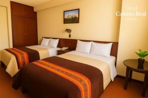 een hotelkamer met twee bedden en een tafel bij Camino Real Puno in Puno