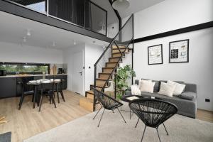 a living room with a staircase and a table and chairs at KASZUBSKI LOFT Sominy in Sominy