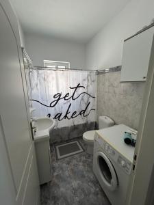 a bathroom with a toilet and a washing machine at The Big Blue in Gythio