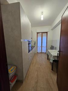 a kitchen with a refrigerator and a table in it at Filoverde vicino il CONI e il mare in Formia