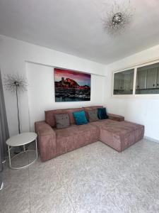 un soggiorno con un divano marrone e un tavolo di Playa de San Juan JULIA ad Alicante