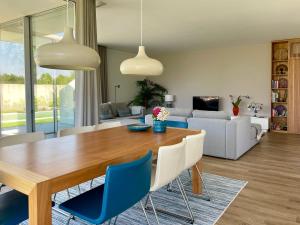 a living room with a wooden table and blue chairs at Villa Mar & Luz, Porto, Mindelo Beach in Mindelo