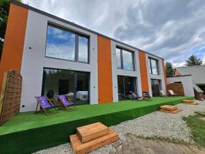 a house with two lawn chairs on the front of it at MARINASURF Baza Wypoczynkowa in Przeczyce