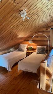 a bedroom with two beds in a wooden cabin at River's Whisper Cottage in Rovaniemi