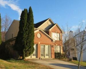 a brick house with a tree in front of it at Cara Drive Room in Springdale
