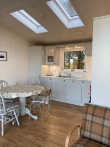 a kitchen with a table and chairs and a sink at Pinelodge, Dunnet Bay in Thurso