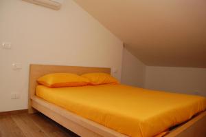 a bed with yellow sheets and pillows in a room at Palazzina Storica al Mare, Rapallo in Rapallo