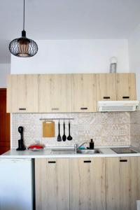 eine Küche mit Holzschränken und einer Spüle in der Unterkunft StuDio 57 (5) in Alexandroupoli