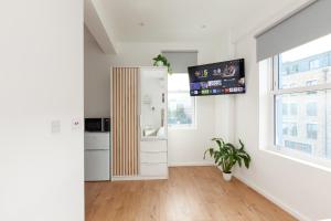 ロンドンにあるVillas Apart Hotelのキッチン(冷蔵庫、壁掛けテレビ付)