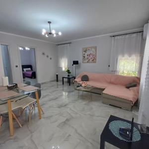 a living room with a pink couch and a table at Casa Chinook Sea View Homes-Porto Koufo in Porto Koufo